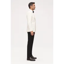 Smoking veste ivoire et pantalon noir porté de profil