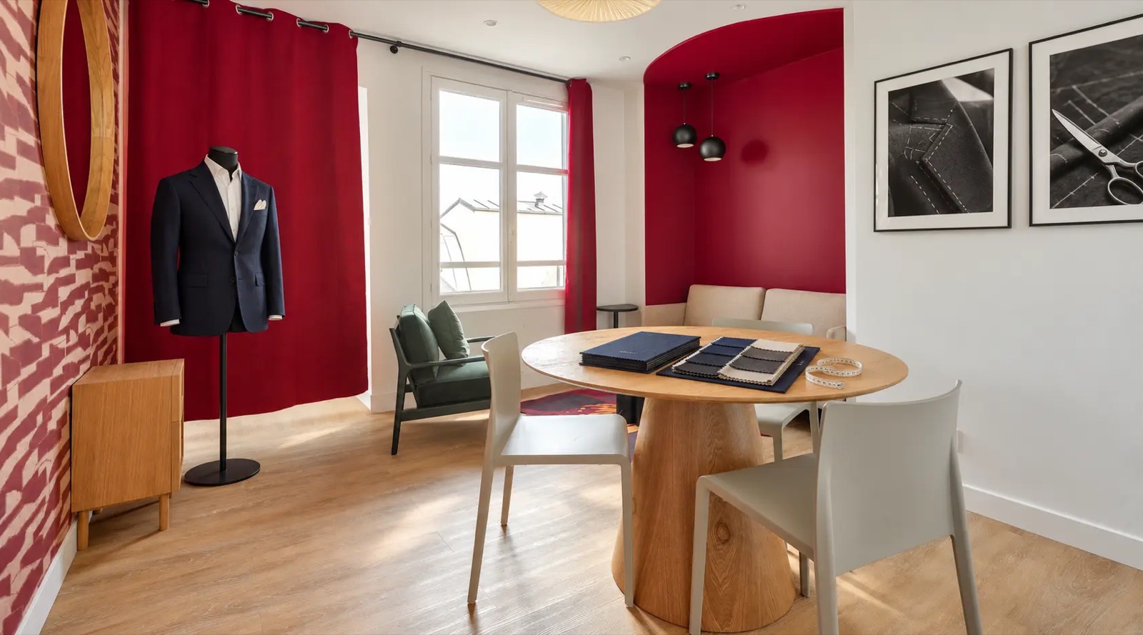 Le salon Faubourg Saint Honoré : table ronde de sélection des tissus, alcôve et rideaux rouges
