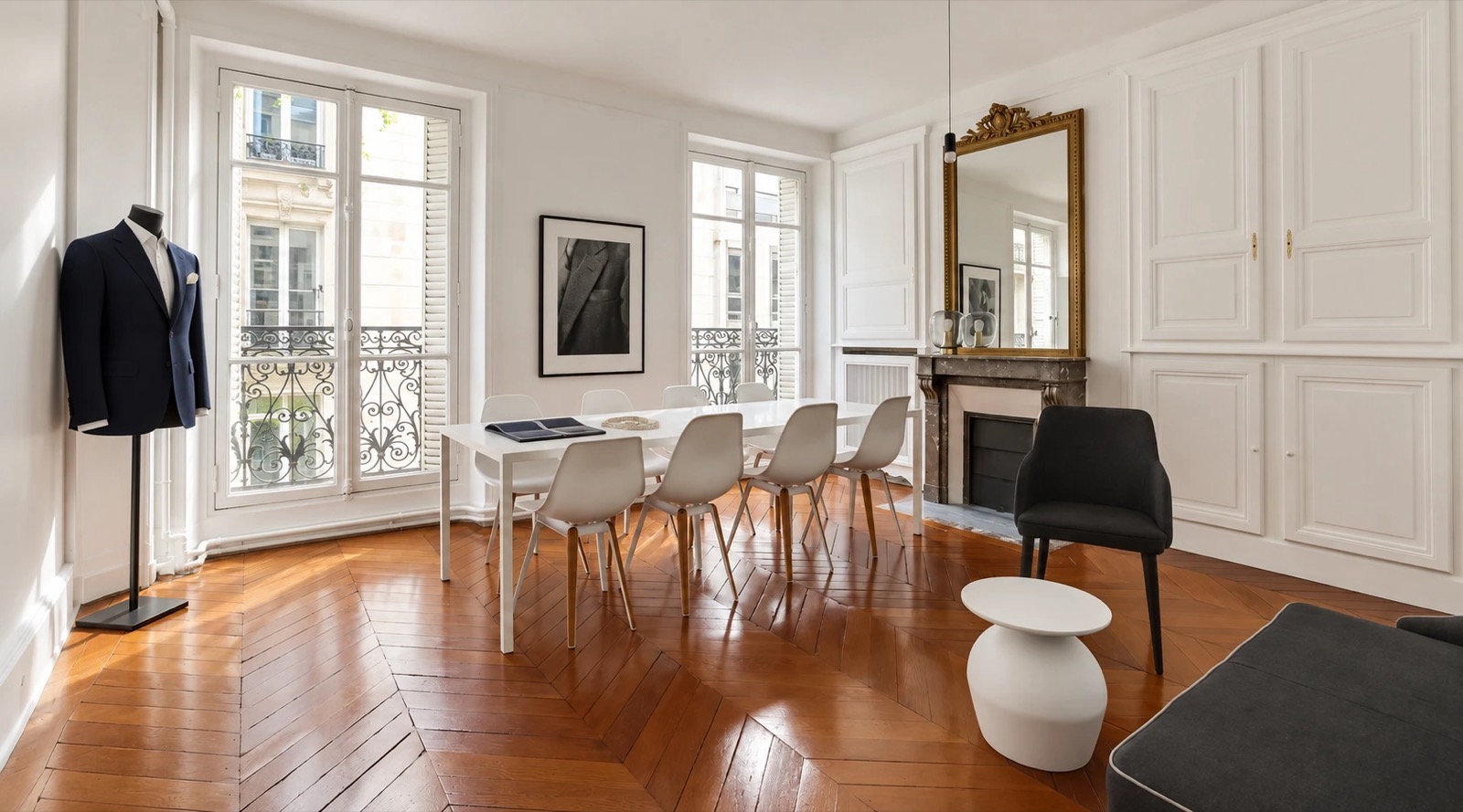 Le salon Pierre Charron : longue table de sélection des tissus, cheminée en marbre et miroir doré